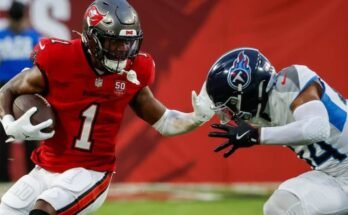 Bucs juoksee takaisin Rachaad White-Arms Titans -turvallisuus Mike Brown lauantaina esikauden ottelun ensimmäisellä neljänneksellä. © Jefferee Woo