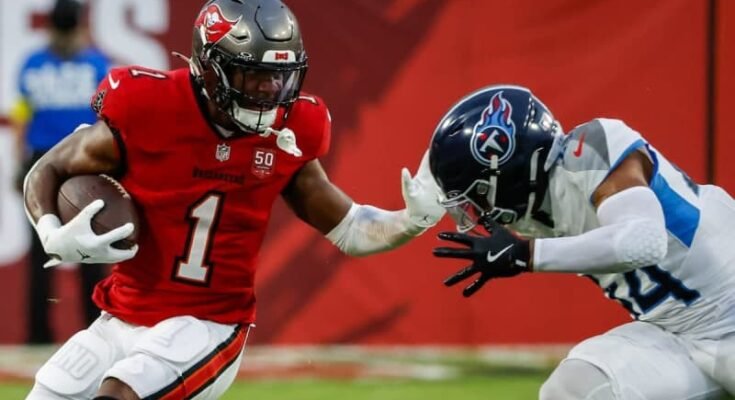 Bucs juoksee takaisin Rachaad White-Arms Titans -turvallisuus Mike Brown lauantaina esikauden ottelun ensimmäisellä neljänneksellä. © Jefferee Woo