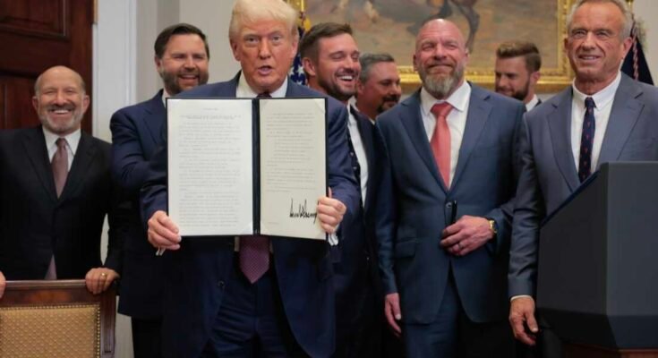 Trump näyttää allekirjoitetun asetuksen, jota ympäröivät virkamiehet ja ammattiurheilijat.