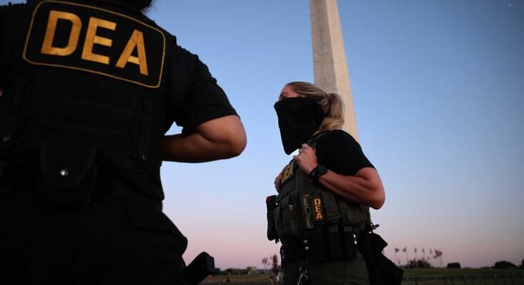 Amerikkalaiset huumeiden edustajat täytäntöönpanovirasto (DEA) partioi Washingtonin muistomerkkiä kansallisessa ostoskeskuksessa 11. elokuuta Washington DC: ssä