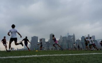 Ihmiset pelaavat rugbyä sumuisella säällä Brooklyn Bridge Parkissa 27. heinäkuuta 2025 New Yorkissa. Huuhde -olosuhteet ja savuilmoitus aiheutti savun metsäpalon jälkeen Kanadassa.