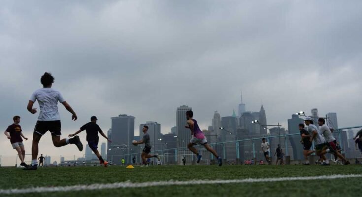Ihmiset pelaavat rugbyä sumuisella säällä Brooklyn Bridge Parkissa 27. heinäkuuta 2025 New Yorkissa. Huuhde -olosuhteet ja savuilmoitus aiheutti savun metsäpalon jälkeen Kanadassa.