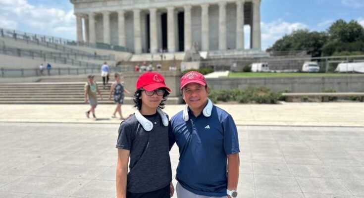 Jeffrey Pagulong (oikealla) ja hänen 12 -vuotiaan pojansa Christof pidetään lähellä Lincoln Memorialia Washington DC: ssä. He molemmat käyttävät punaisia baseball -lippeja ja valkoisia kaulan jäähdytysfaneja.