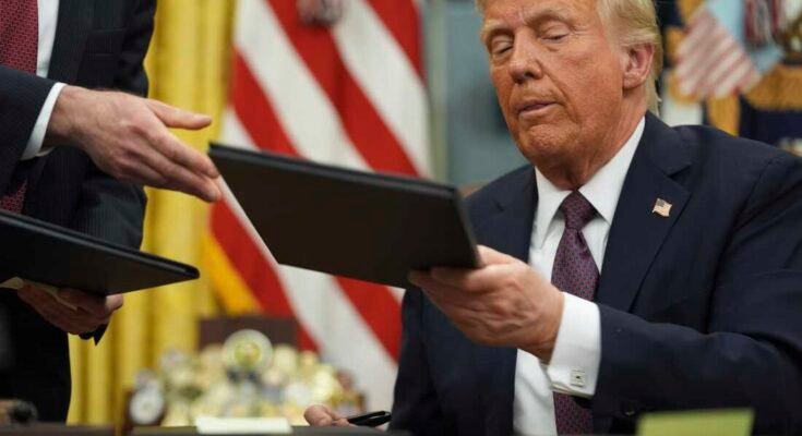 Presidentti Donald Trump allekirjoittaa päätökset Valkoisen talon soikea toimistossa 20. tammikuuta.