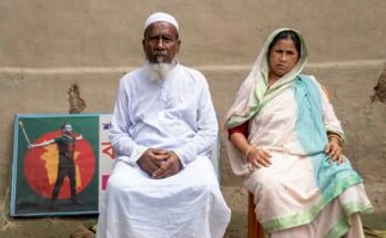 Abu Sayedin, Mokbul Husseinin ja Monowara Khatunin vanhemmat istuvat talonsa pihalla Rangpurissa, Bangladeshissa, 30. heinäkuuta. Heidän takana olevassa seinässä, muistolaatta, joka oli omistettu heidän pojalleen, jonka poliisi tappoi mielenosoituksissa viime vuonna.